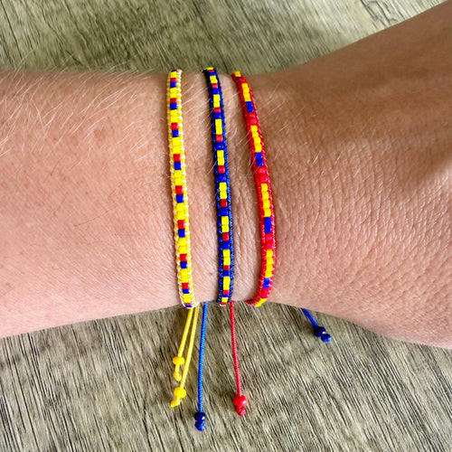 Colorful beaded bracelets on a wrist with a wooden surface background
